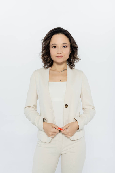 Brunette businesswoman in formal wear looking at camera isolated on grey  - Zdjęcie, obraz