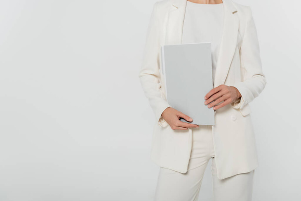 Cropped view of businesswoman in formal wear holding paper folder isolated on grey  - Photo, Image