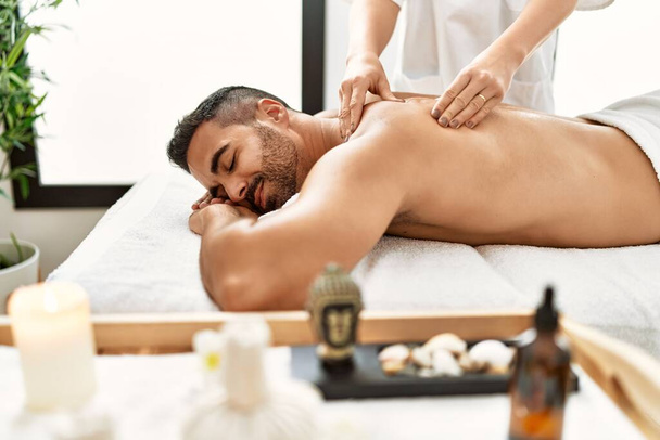 Jovem hispânico homem tendo massagem nas costas no centro de beleza - Foto, Imagem