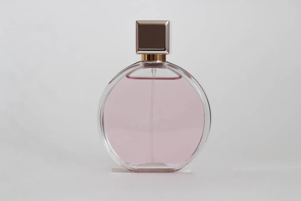 Pembe bir kutudan çıkan parfüm şişesi izole bir arka planda, maket ve kopyasal alan ile birlikte. - Fotoğraf, Görsel