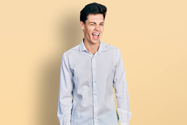 Jonge Latijns-Amerikaanse zakenman draagt zakelijke kleding knipogen naar de camera met sexy uitdrukking, vrolijk en gelukkig gezicht.  - Foto, afbeelding