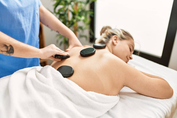 Woman couple having back treatment using hot black stones at beauty center - Valokuva, kuva
