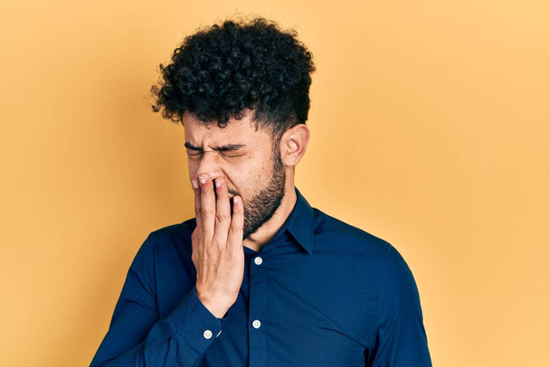 Young arab man with beard wearing casual shirt bored yawning tired covering mouth with hand. restless and sleepiness.  - Photo, Image