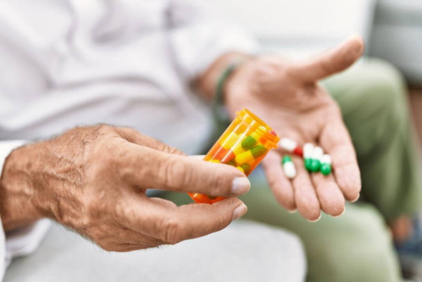 Senior man holding pills at home - Foto, imagen
