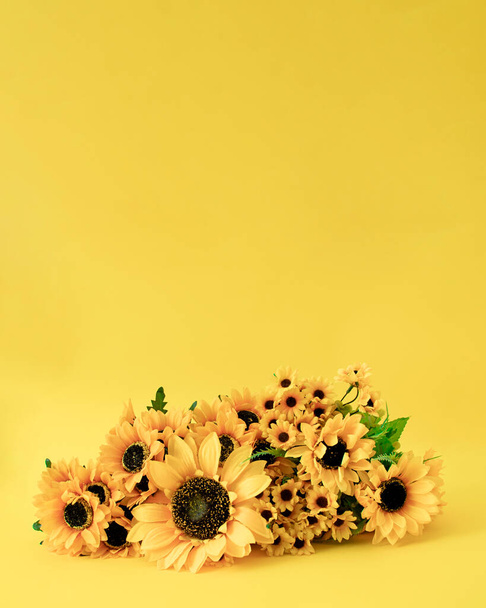 Kreatives Konzept von frischen Sonnenblumenblüten. Einladungskarte für Frühling und Sommer. Pastellgelber Hintergrund. - Foto, Bild