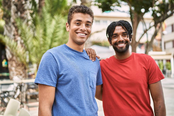 İki Afro-Amerikan adam gülümseyerek şehirde mutlu mesut dikiliyor.. - Fotoğraf, Görsel