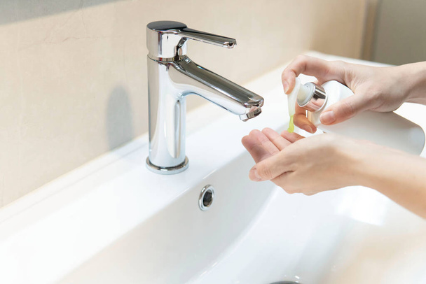 Střední detailní záběr, žena používající mýdlo, aby si doma umyla ruce v koupelně. Detailní záběr konceptu hygieny rukou. Ochrana proti infekcím a virům. - Fotografie, Obrázek