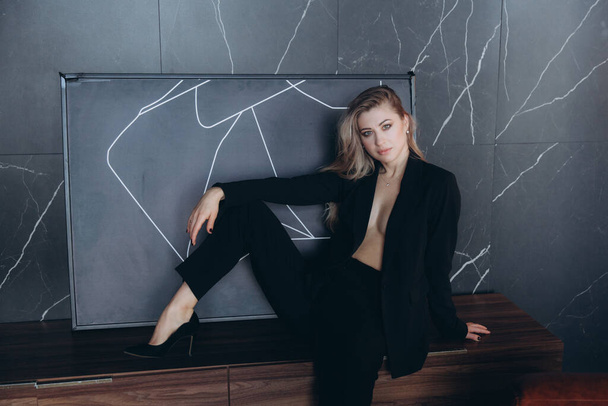 Beautiful girl, blonde, in a black suit, office style, work clothes, no war, Ukraine - Foto, afbeelding