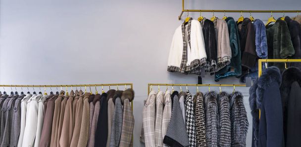 Manteaux de printemps pour femmes suspendus sur un rack dans un magasin de vêtements pour femmes - Photo, image
