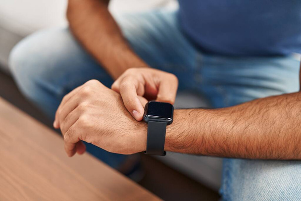 Jovem hispânico usando smartwatch em casa - Foto, Imagem