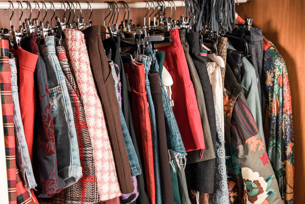 Różne kolorowe ubrania damskie wiszące w szafie lub chodzić we wnętrzu szafy na poręczy w zbliżeniu - Zdjęcie, obraz