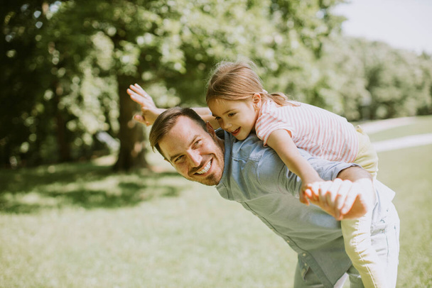 Vater mit süßer kleiner Tochter hat Spaß im Park - Foto, Bild