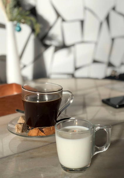 Glass mug of milk and americano coffee with dark sugar in cafe - Φωτογραφία, εικόνα