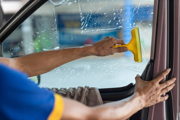 Technician Installing car window tint. Car window tinting series. Car window tinting specialist install car film windscreen. - Фото, зображення