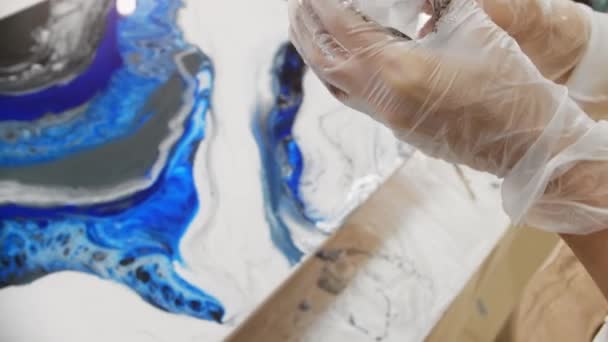 Diseño epoxi - verter resina epoxi blanca en la superficie de pintura de la taza de plástico - Metraje, vídeo