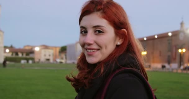 İtalyan meydanında sırt çantalı genç bir kız kameraya gülümsüyor. - Video, Çekim