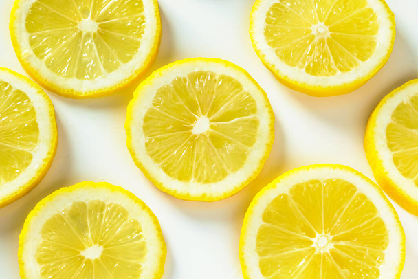 Friss, szaftos citromos közelkép háttere. Érett sárga citrusszeletek mintája. - Fotó, kép