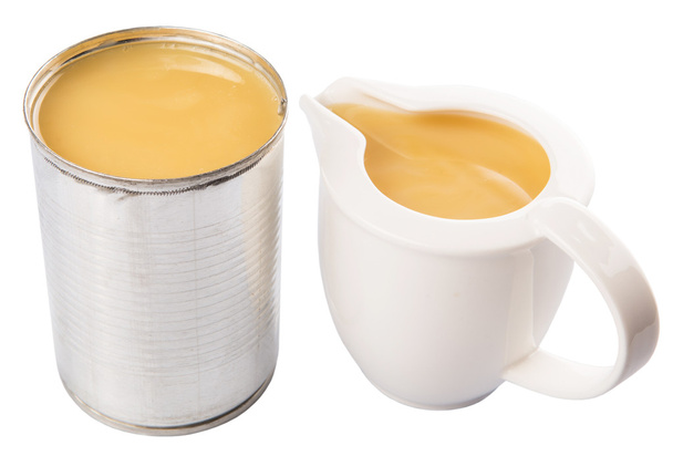 Leche condensada en lata y jarra de leche
 - Foto, imagen