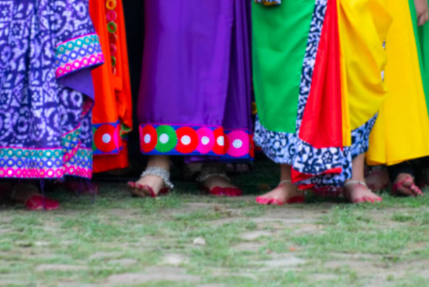 Imagen borrosa de coloridas cortinas de sari, vestido tradicional indio. Jóvenes bailarines bengalíes esperan su turno para disfrutar y bailar en el festival Holi, celebrado en Kolkata, Bengala Occidental, India. - Foto, Imagen
