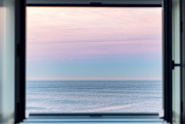 Ανατολή ηλίου πάνω από τον Ατλαντικό Ωκεανό μέσα από το ανοιχτό παράθυρο - Φωτογραφία, εικόνα