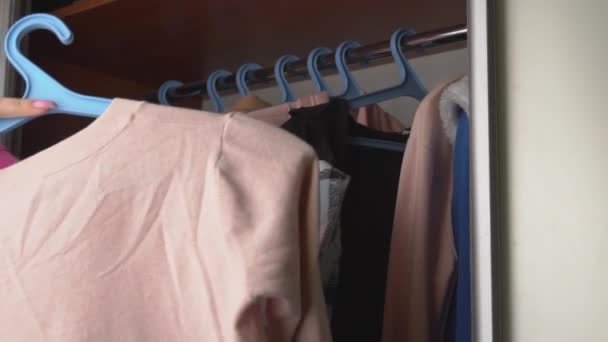 Девушка выбирает вещи в гардеробе - Кадры, видео