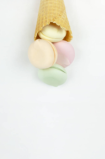 Zoete, heldere marshmallow lijkt op macarons in de vorm van een ijsje in een wafelbeker, concept van zoet dessert - Foto, afbeelding