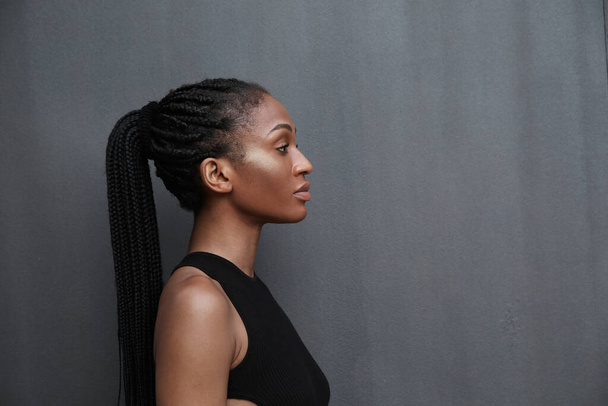 Profile portrait of black confident woman with long braids posing outdoor. - Φωτογραφία, εικόνα