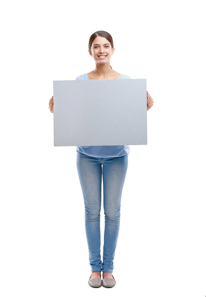 Pon tu anuncio aquí. Retrato de estudio de cuerpo entero de una atractiva joven sosteniendo un signo gris en blanco. - Foto, imagen