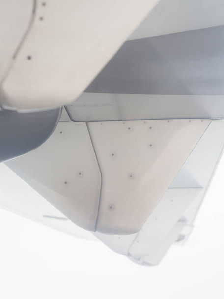 Een deel van de vleugel van een klein vliegtuig is zichtbaar vanuit de patrijspoort tegen de achtergrond van een mistige lucht. Zachte focus - Foto, afbeelding