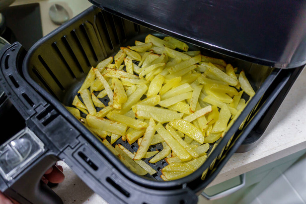 Домашняя картошка фри, сделанная во фритюрнице. Здоровая концепция приготовления пищи без масла - Фото, изображение