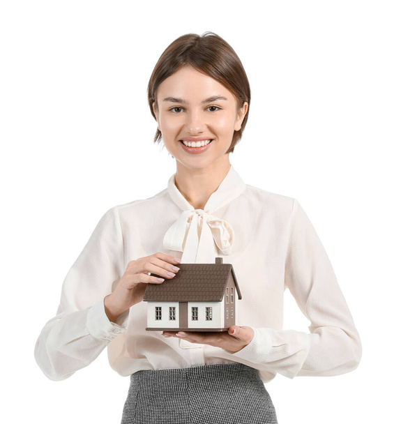 Female real estate agent with figure of house on white background - Φωτογραφία, εικόνα