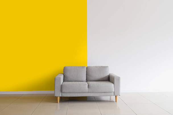 Grey sofa near yellow and white wall - Photo, Image