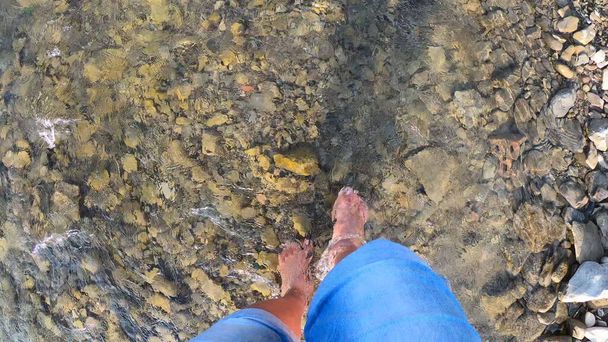 Menina andando descalça sobre pedras de rio raso close-up, dia ensolarado de verão - Foto, Imagem