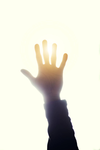 Its bright out. Cropped shot of a persons hand raised and blocking the sun. - Photo, Image