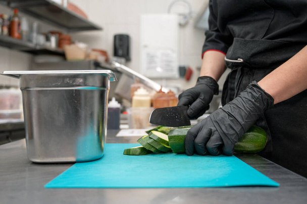 Female chef cutting vegetables at a commercial kitchen.  - Photo, Image
