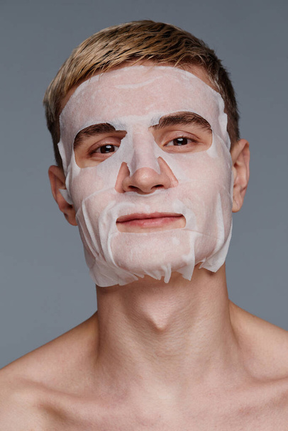 Young Man with Moisturizing Face Mask - Foto, afbeelding