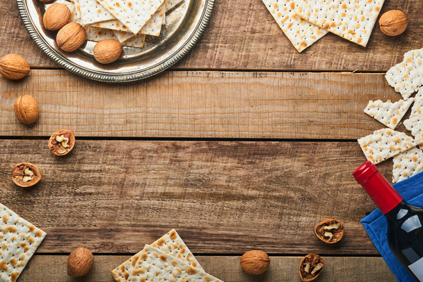 Matzah, red kosher and walnut. Traditional ritual Jewish bread on old wooden rustic background. Passover food. Pesach Jewish holiday of Passover celebration concept. - Photo, image