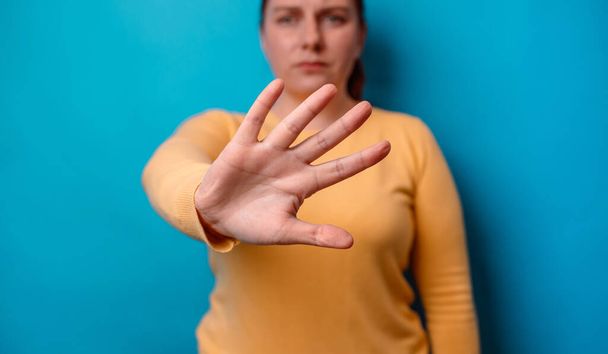 戦争はやめて。女性は青の背景に隔離されたコピースペースとの暴力を停止するキャンペーンのために彼女の手を上げ - 写真・画像