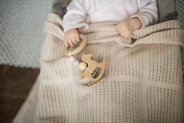 a small child with a toy in a cocoon, a baby in a lounger - Foto, afbeelding