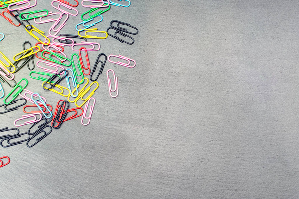 colored paper clips on a dark background - Foto, imagen