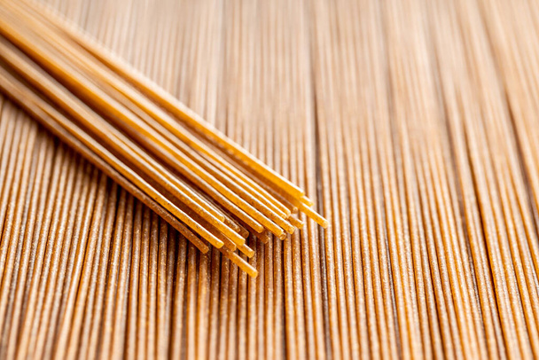 Uncooked whole grain spaghetti pasta. Raw pasta  - Fotoğraf, Görsel