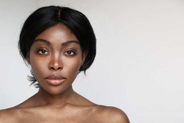 Beautiful black woman with clean healthy skin posing on white background. - Zdjęcie, obraz