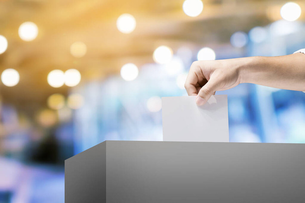 Рука проведение избирательного бюллетеня для голосования на месте выборов ба - Фото, изображение