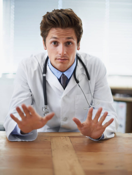 No need to worry at this point.... Shot of a young doctor gesturing not to worry to the camera. - Photo, Image