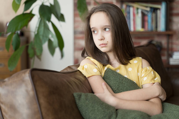 frustrated thoughtful teen girl sitting on the couch in the living room - 写真・画像