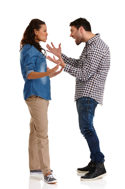 İlişki sorunları. Stüdyoda genç bir çiftin, beyazların üzerinde agresif bir şekilde tartışırken çekilmiş bir fotoğrafı.. - Fotoğraf, Görsel