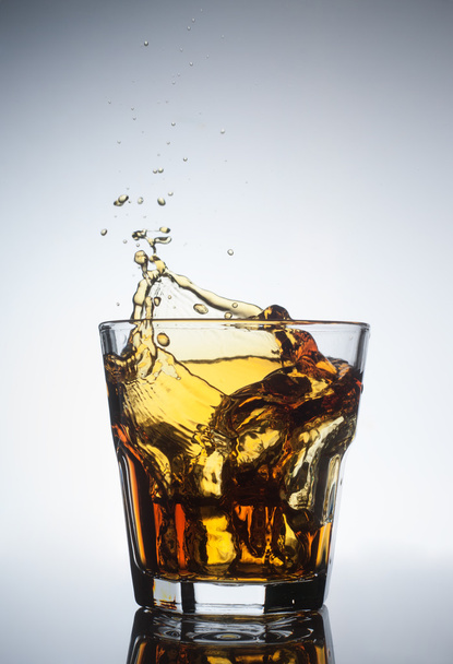Isolated shots of whiskey with splash on white - 写真・画像