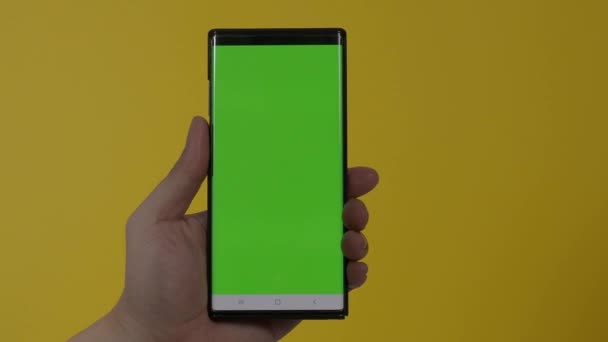 Smartphone screen. Smart phone isolated on color background. Green screen chroma key technique. Man hand touching on mobile phone green screen. Using smartphone display. hand gestures. 4K footage. - Footage, Video
