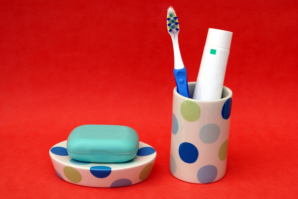 Аксессуары для ванной Зубная щетка и зубная паста в чашке. Мыло на тарелке
 - Фото, изображение