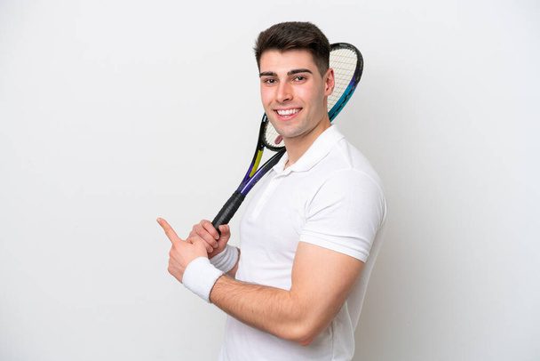 jovem jogador de tênis homem isolado no fundo branco apontando para trás - Foto, Imagem